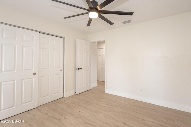 unfurnished bedroom with light hardwood / wood-style flooring, a closet, and ceiling fan