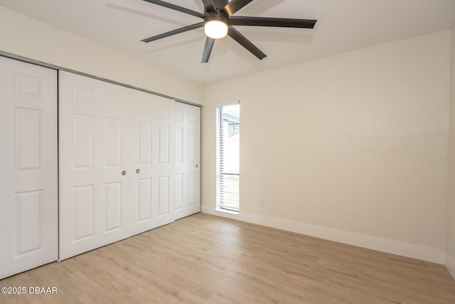 unfurnished bedroom with light wood-type flooring, ceiling fan, and a closet