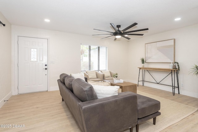 living room with light hardwood / wood-style flooring and ceiling fan