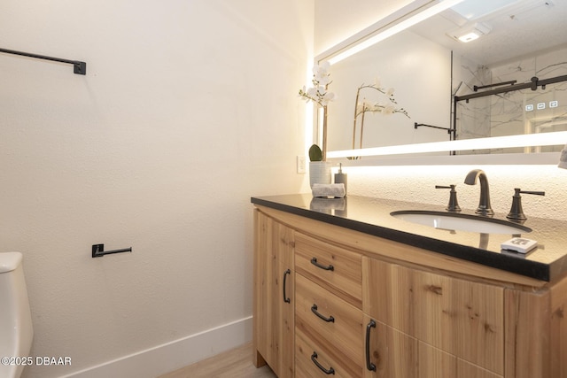 bathroom featuring hardwood / wood-style flooring, vanity, toilet, and walk in shower