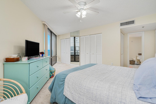 carpeted bedroom with ceiling fan and a textured ceiling