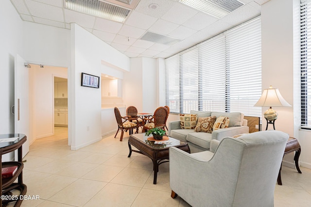 tiled living room with a paneled ceiling