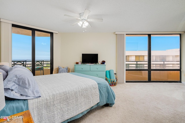 bedroom with ceiling fan, carpet, a textured ceiling, and access to exterior