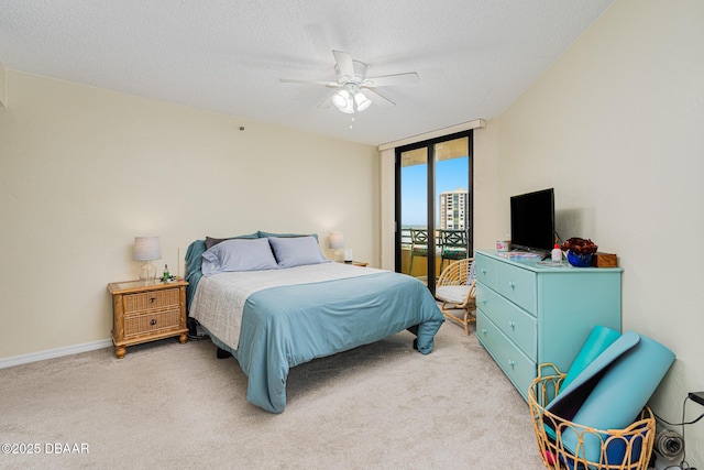 carpeted bedroom with a textured ceiling, ceiling fan, and expansive windows