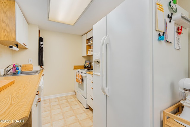 kitchen with white appliances, white cabinets, and sink