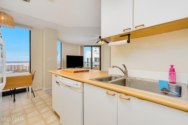 kitchen featuring white dishwasher, ceiling fan, white cabinetry, and plenty of natural light