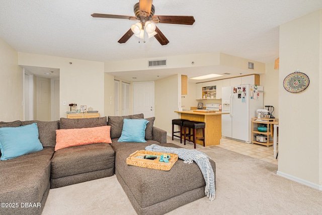 living room featuring ceiling fan and a textured ceiling