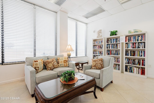 sitting room featuring light tile patterned flooring and a drop ceiling