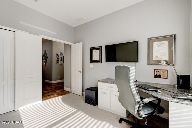 carpeted home office featuring built in desk