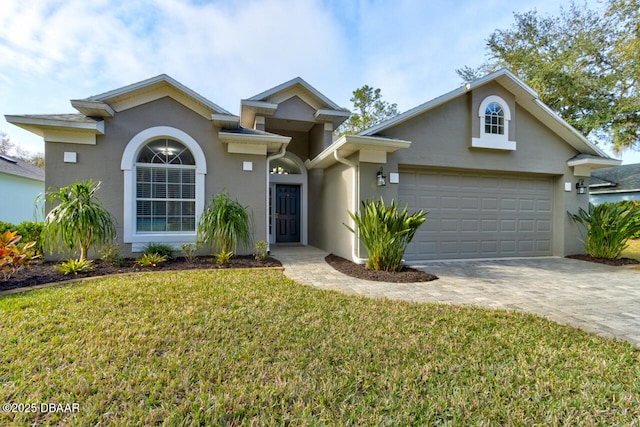 view of property featuring a garage and a front lawn