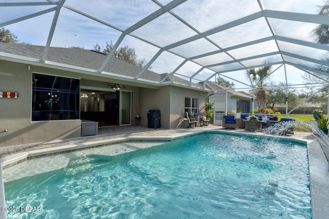 view of pool with outdoor lounge area, a lanai, pool water feature, ceiling fan, and a patio area