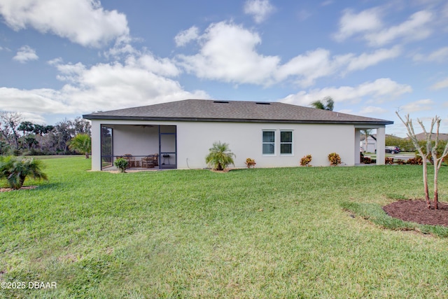 rear view of property featuring stucco siding, a sunroom, and a yard