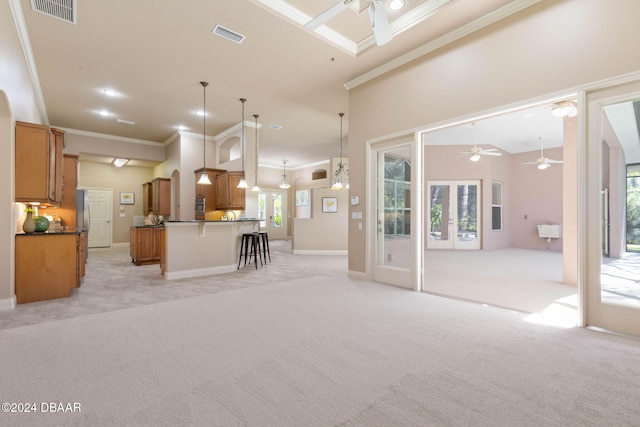 interior space with plenty of natural light, crown molding, light colored carpet, and hanging light fixtures