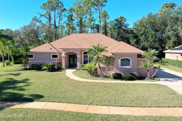 3404 Rexford Cir, Ormond Beach, FL 32174 - mediterranean / spanish-style home featuring stucco siding, a front lawn, driveway, and roof with shingles