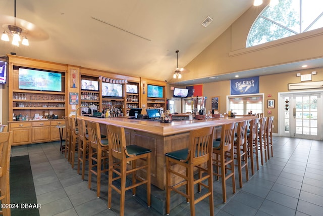 3404 Rexford Cir, Ormond Beach, FL 32174 - community bar area featuring dark tile patterned floors, high vaulted ceiling, and healthy amount of natural light