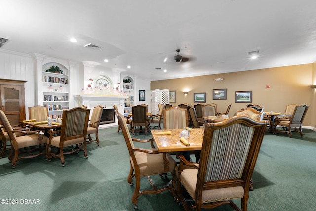 carpeted dining room with ceiling fan, ornamental molding, and built in shelves