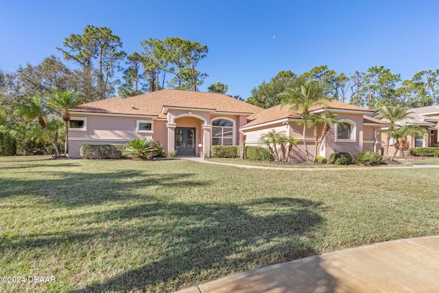 3404 Rexford Cir, Ormond Beach, FL 32174 - mediterranean / spanish-style house with stucco siding, a front yard, and french doors