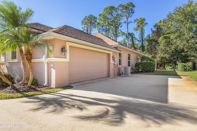 view of front of house with central AC and a garage