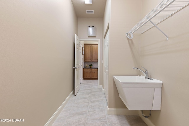3404 Rexford Cir, Ormond Beach, FL 32174 - laundry area featuring baseboards, a sink, and light tile patterned floors