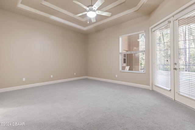 unfurnished room with carpet flooring, ceiling fan, a raised ceiling, and crown molding