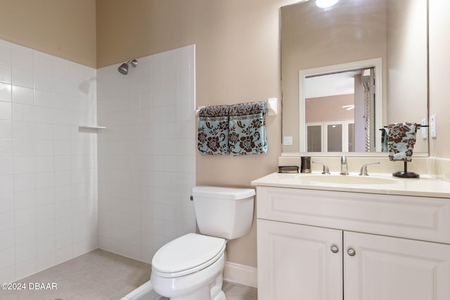 bathroom with tile patterned flooring, a tile shower, vanity, and toilet