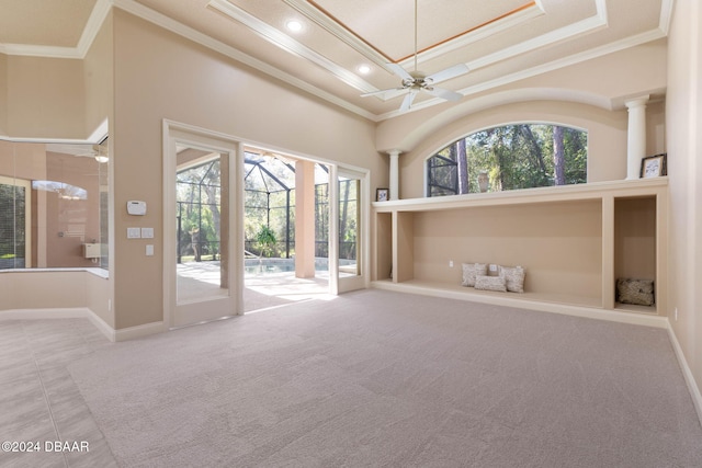 carpeted empty room with a high ceiling, ceiling fan, and crown molding