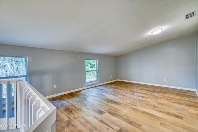 spare room with light wood-type flooring, baseboards, and visible vents