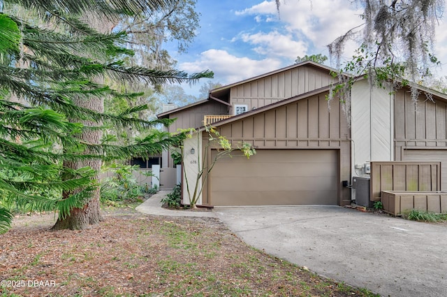 view of front of home with driveway, board and batten siding, an attached garage, and cooling unit