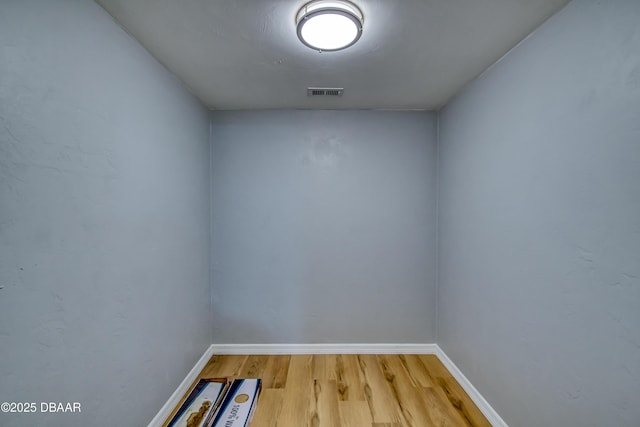 interior space featuring wood finished floors, visible vents, and baseboards