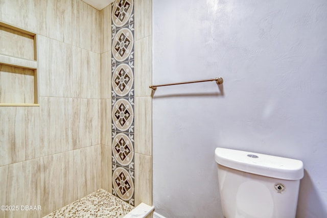 bathroom with tiled shower and toilet