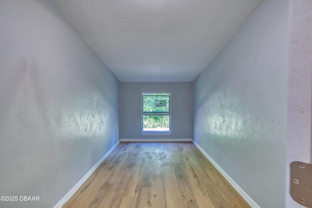 unfurnished room with baseboards and light wood finished floors