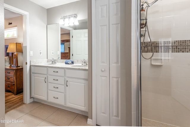 bathroom featuring tile patterned flooring, vanity, and tiled shower