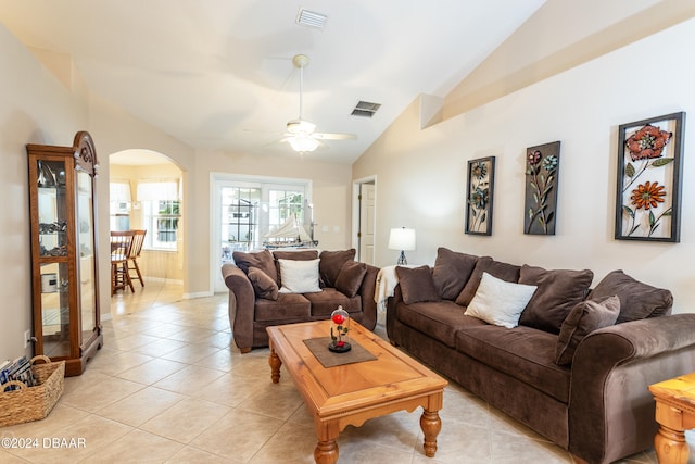 living room with ceiling fan, light tile patterned floors, and vaulted ceiling