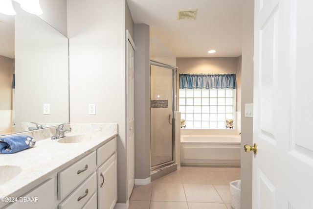 bathroom featuring tile patterned flooring, vanity, and shower with separate bathtub