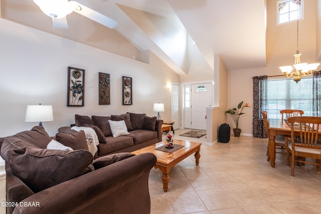 living room with a high ceiling, ceiling fan with notable chandelier, and a healthy amount of sunlight