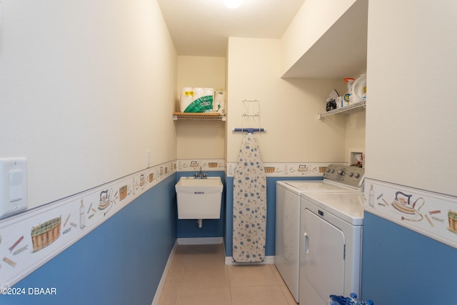 laundry area featuring washer and dryer, light tile patterned floors, and sink