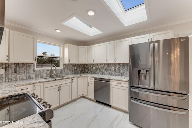 kitchen with appliances with stainless steel finishes, white cabinets, light stone counters, and sink