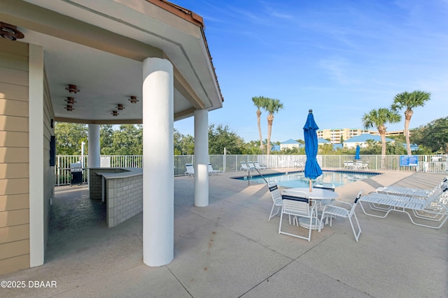 view of swimming pool with a bar and a patio area