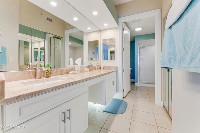 bathroom featuring tile patterned flooring, vanity, and a shower with shower door