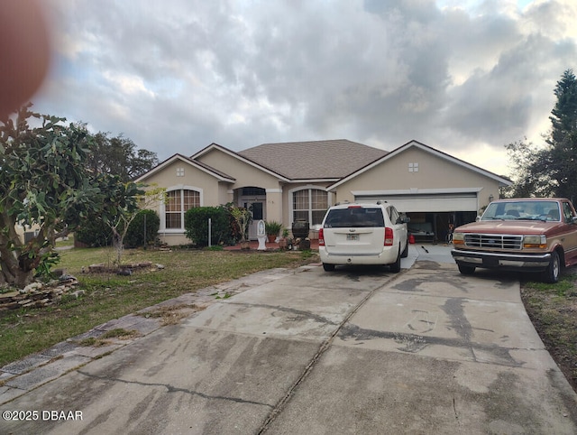 single story home featuring an attached garage, a shingled roof, concrete driveway, and stucco siding