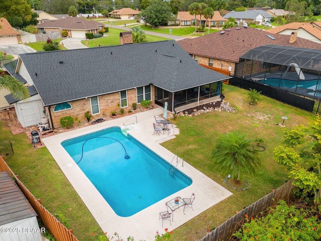 view of swimming pool with a sunroom, a lawn, and a patio