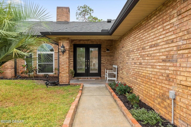 entrance to property featuring french doors and a yard