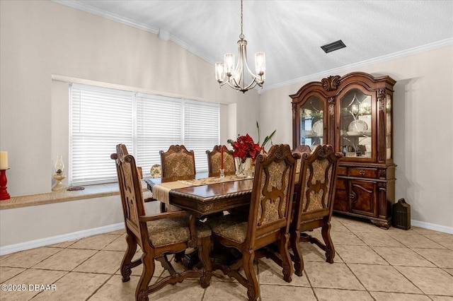 dining room with a textured ceiling, an inviting chandelier, ornamental molding, and light tile patterned flooring