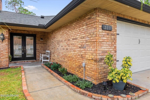 view of exterior entry with a garage and french doors