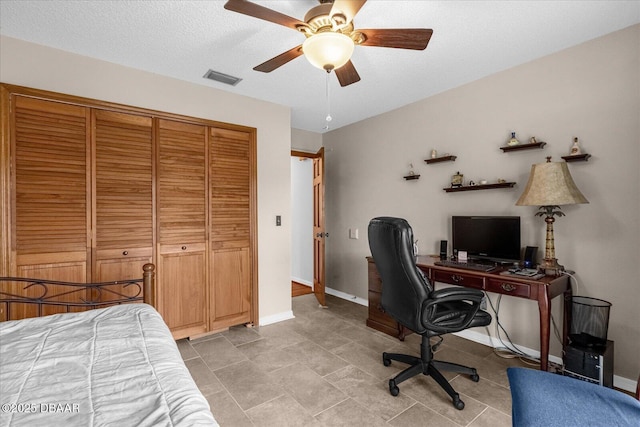 bedroom featuring ceiling fan, a closet, and a textured ceiling