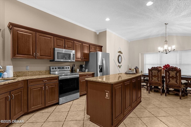 kitchen featuring a notable chandelier, a center island, pendant lighting, crown molding, and appliances with stainless steel finishes