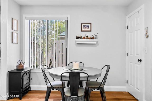 dining space with baseboards and light wood finished floors