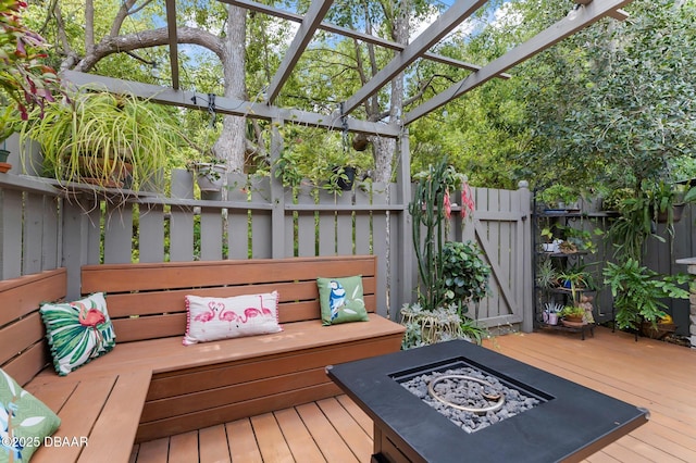 deck with a fire pit and fence