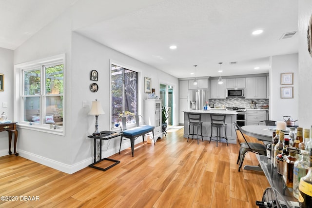 dining space with light wood-style floors, baseboards, recessed lighting, and visible vents
