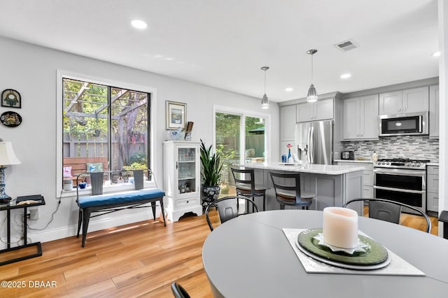 dining area with light wood-style floors, baseboards, recessed lighting, and visible vents